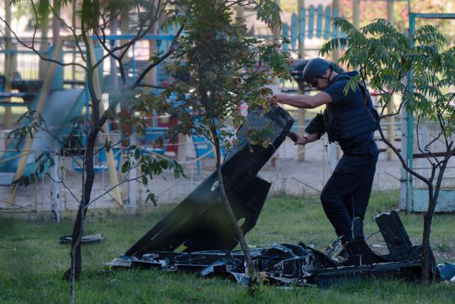 A Ukrainian expert examines debris of a Russian drone that crashed near a children's playground among residential buildings and did not detonate, in Kyiv on September 30, 2026, amid the Russian invasion of Ukraine. (Photo by Genya SAVILOV / AFP)