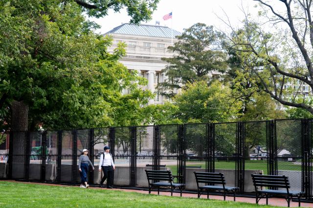 Tourists walk along a fence line in Lafayette Park near the White House in Washington, DC, September 30, 2026, following a partial re-opening of the park after a renovation. (Photo by SAUL LOEB / AFP)