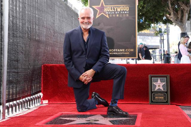 US actor Bradley Whitford kneels down at his newly unveiled Hollywood Walk of Fame star in Hollywood, California on September 30, 2026. (Photo by VALERIE MACON / AFP)