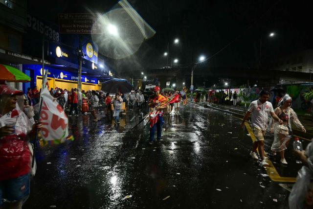 Supporters of Brazil's President and presidential candidate Luiz Inacio Lula da Silva leave a campaign event after it was suspended due to rain in Juiz de Fora, Minas Gerais state, Brazil, on September 30, 2026. Brazil will hold presidential election on October 4, 2026. (Photo by Pablo PORCIUNCULA / AFP)