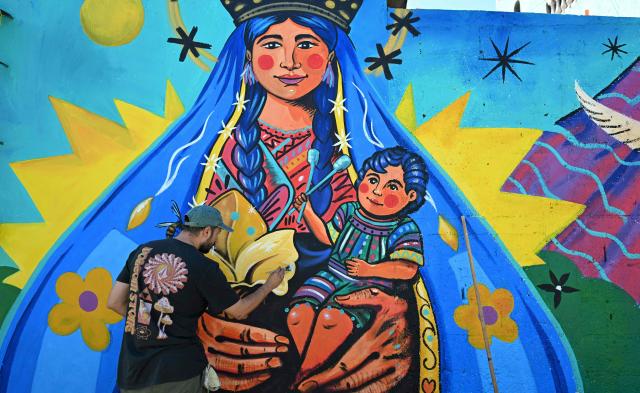 Guatemalan artist Luis Fernando Izquierdo retouches his mural of the Virgin Mary and the child Jesus on the streets of Santa Marнa de Jesъs, Guatemala on September 30, 2026. The murals are part of “"A New Air for Santa Maria de Jesus" an initiative that seeks to restore deteriorated spaces and strengthen the identity of this community through art. (Photo by Johan ORDONEZ / AFP)