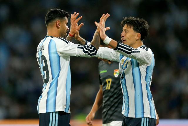 Argentina's defender #13 Cristian Romero (L) celebrates with teammate defender #06 Lisandro Martinez after scoring his team's third goal during the international friendly football match between Argentina and Bolivia at Mario Alberto Kempes Stadium in Cordoba, Argentina, on September 30, 2026. (Photo by Diego Lima / AFP)