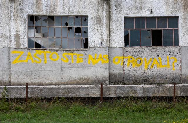 A photo shows a graffito reading "Why did you poison us?" on the wall of the silo of the former PPK Velebit agro-food industrial complex where waste was illegally dumped and buried in Gospic, Croatia's Lika region, on September 21, 2026. As Croatia prepares to clean up tens of thousands of tonnes of hazardous waste dumped in the heart of its idyllic Lika region, locals fear years of illegal dumping may have spread into its pristine surrounds. (Photo by MARKO PERKOV / AFP)