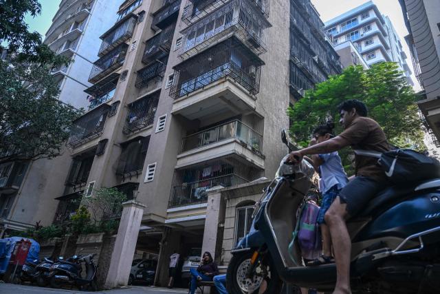 A resident drives past a building which resides relatives of Smit Machchhar, an Indian national flydubai pilot in Mumbai on October 1, 2026. Israel's leader credited the pilot and passengers of a Dubai-Tel Aviv flight with averting catastrophe on September 30 after they overpowered a co-pilot who allegedly tried to crash the aircraft, forcing an emergency landing. (Photo by Punit PARANJPE / AFP)