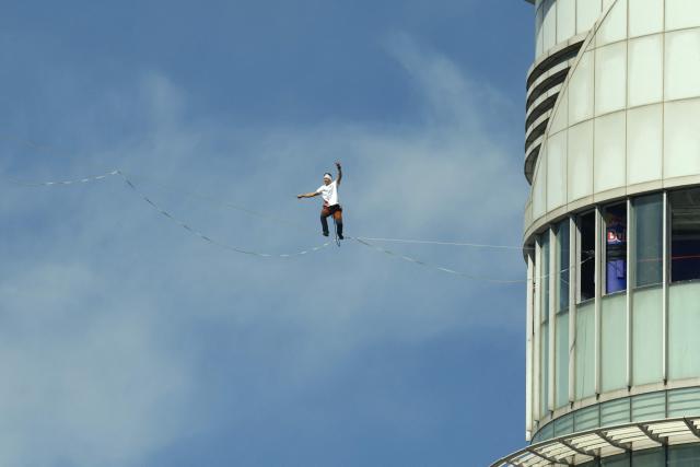 Estonia's Jaan Roose performs on a slackline during South Korea's first urban highline crossing event, 160 metres long and suspended 120 metres above the ground, in central Seoul on October 1, 2026. (Photo by Han Myung-Gu / POOL / AFP)