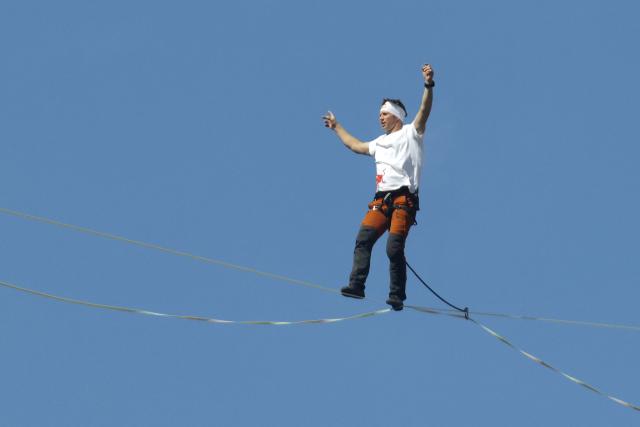 Estonia's Jaan Roose performs on a slackline during South Korea's first urban highline crossing event, 160 metres long and suspended 120 metres above the ground, in central Seoul on October 1, 2026. (Photo by Han Myung-Gu / POOL / AFP)