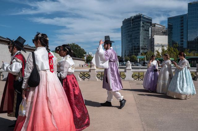 Foreign tourists in traditional Hanbok outfits visit Gyeongbokgung Palace in Seoul on October 1, 2026. (Photo by Philip FONG / AFP)
