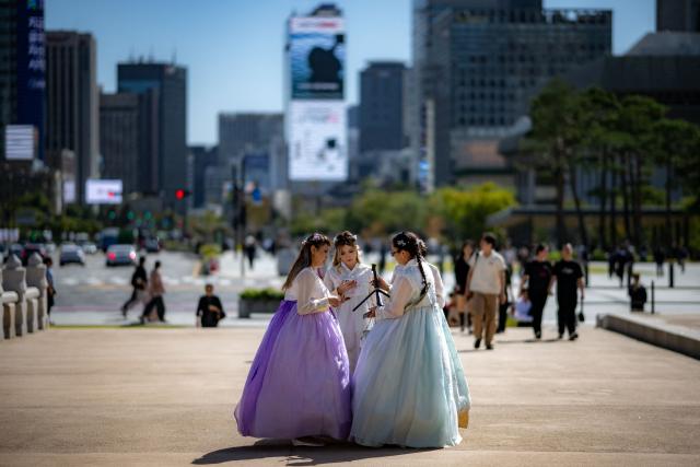 Foreign tourists in traditional Hanbok outfits visit Gyeongbokgung Palace in Seoul on October 1, 2026. (Photo by Philip FONG / AFP)