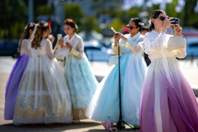 Foreign tourists in traditional Hanbok outfits visit Gyeongbokgung Palace in Seoul on October 1, 2026. (Photo by Philip FONG / AFP)