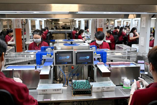 Workers craft jewellery at Pandora's new manufacturing plant in Ho Chi Minh City on October 1, 2026, as the world's biggest jewellery brand opened the facility it said will be able to produce up to 60 million pieces each year. Danish company Pandora said the $150 million plant outside Ho Chi Minh City would create 7,000 local jobs and become the world's largest crafting facility for fine jewellery. (Photo by Nhac NGUYEN / AFP)