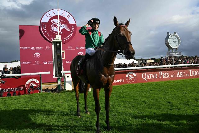 (FILES) French jockey Mickael Barzalona celebrates atop Daryz after winning the Qatar Prix de l'Arc de Triomphe horse race at the Paris Longchamp race course in Paris, on October 5, 2025. They will thunder along at more than 60km per hour for just over two minutes across 2,400 metres in pursuit of the holy grail of flat racing: 16 thoroughbreds of illustrious French, Irish, British and Japanese bloodlines, including defending champion Daryz, will line up on Sunday for the Prix de l'Arc de Triomphe at ParisLongchamp. (Photo by Anna KURTH / AFP)