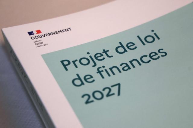 This photograph shows a view of a document reading "projet de loi de finances PLF 2027" after the 2027 state draft budget (PLF) and social security financing bill (PLFSS) for 2027 were presented, in Paris, on October 1, 2026. (Photo by Ludovic MARIN / AFP)