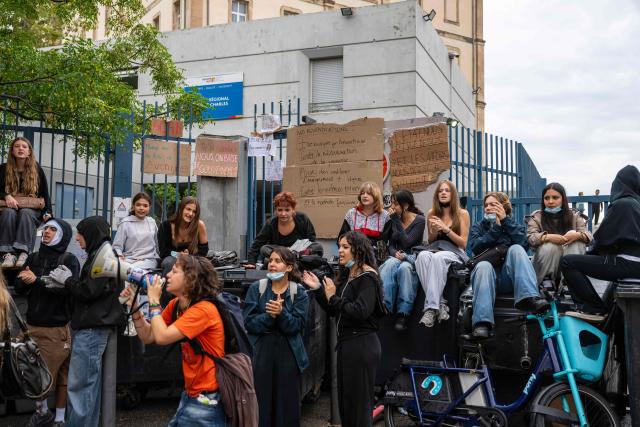 Protesting students carry out blockading action with placards in front of the Saint-Charles secondary school amid high school and student protests, in Marseille, southern France, on October 1, 2026. Since late September, students have staged protests outside schools over grievances ranging from timetables, class sizes and a shortage of teachers to overheated classrooms during this year's heatwaves. The protests started in the Ile-de-France region around Paris but have now spread to other cities nationwide. (Photo by Miguel MEDINA / AFP)