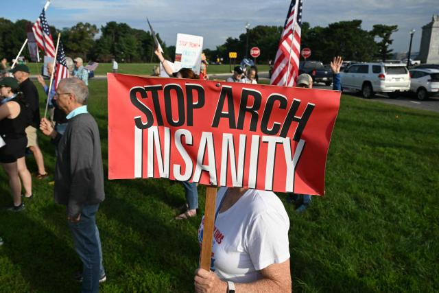 Demonstrators protest against US President Donald Trump's planned "triumphal arch" at Memorial Circle in Washington, DC on October 1, 2026. Trump has said the massive arch he wants to build on a historic location will double as a base for drones and snipers. The proposed giant structure along the Potomac River near the Arlington National Cemetery is part of Trump's drive to put his personal stamp on the capital. (Photo by SAUL LOEB / AFP)