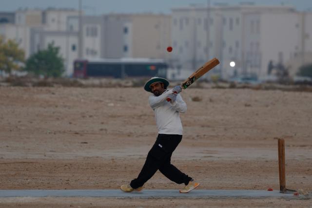 A foreign worker plays cricket at sunset in Doha on October 1, 2026. (Photo by KARIM JAAFAR / AFP)