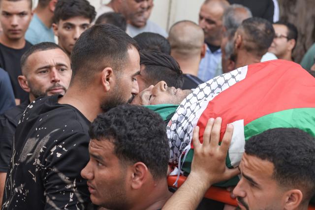 EDITORS NOTE: Graphic content / Relatives carry the body of Palestinian Mashhour Yassin, 51, at the Salfit Hospital in Salfit in the Israeli-occupied West Bank on October 1, 2026, after he was shot dead by Israeli settlers during a raid on the village of Yasuf southwest of Nablus, according to the mayor and the Palestinian health ministry. The raid came as international criticism mounts over surging levels of settler violence against Palestinians in the territory, which Israeli Prime Minister Benjamin Netanyahu downplayed last week. Israel's military told AFP it was looking into the details of the attack. (Photo by JAAFAR ASHTIYEH / AFP)