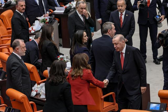 Turkish President Recep Tayyip Erdogan (R) shake hands with members of the Equality and Democracy (DEM) Party during the opening of the parliamentary session at the Grand National Assembly of Turkey (TBMM) in Ankara, on October 1, 2026. (Photo by Adem ALTAN / AFP)