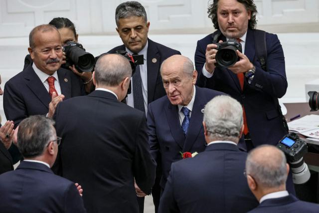 Turkish President Recep Tayyip Erdogan (CL) shakes hands with leader of the Turkish Nationalist Movement Party (MHP), Devlet Bahceli (CR), during the opening of the parliamentary session at the Grand National Assembly of Turkey (TBMM) in Ankara, on October 1, 2026. (Photo by Adem ALTAN / AFP)