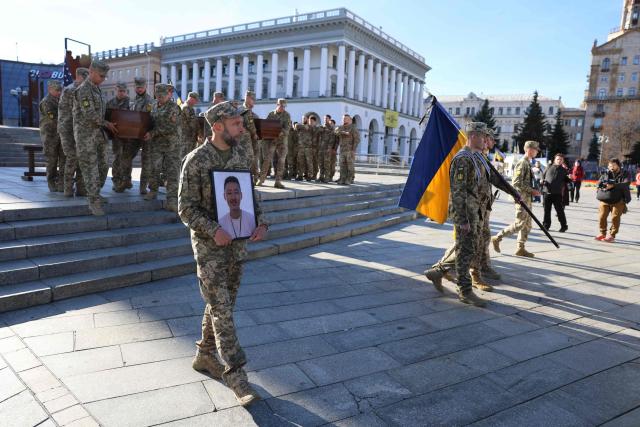Ukrainian soldiers carry the coffins of US fighters Benjamin Yoo and Spencer Burns Meek, who were killed in combat after voluntarily joining the ranks of the Armed Forces of Ukraine, during a funeral ceremony on Independence Square in Kyiv on October 1, 2026, during the Russian invasion of Ukraine. The farewell ceremony was organised with the support of the R T Weatherman Foundation who has supported the families of service members killed and missing in action providing comprehensive care, support, and help to honour the memory of the fallen Heroes. (Photo by AFP)