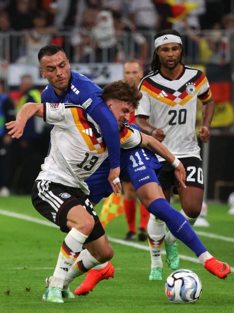 Germany's defender #13 Philipp Treu and Serbia's midfielder #11 Filip Kostic vie for the ball during the UEFA Nations League Group A2 between Germany and Serbia at the Allianz Arena in Munich, southern Germany on October 1, 2026. (Photo by Karl-Josef HILDENBRAND / AFP)