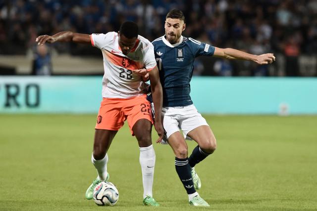Netherlands' defender #22 Denzel Dumfries (L) and Greece's forward #07 Giorgos Masouras (R) fight for the ball during the UEFA Nations League Group A2 football match between Greece and The Netherlands at the Toumba Stadium in Thessaloniki on October 1, 2026. (Photo by Sakis Mitrolidis / AFP)