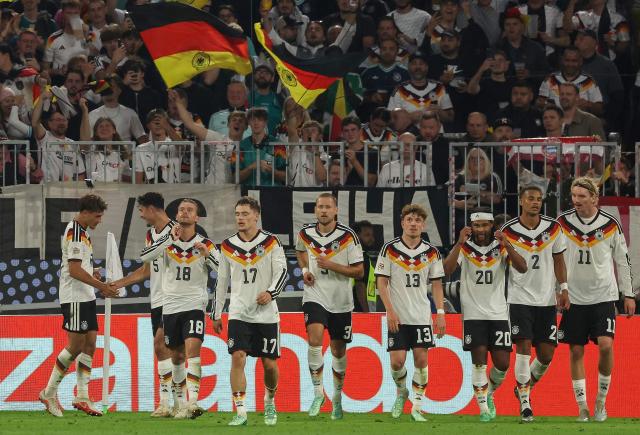 Germany's midfielder #08 Tom Bischof (L) celebrates scoring the opening goal with his teammates during the UEFA Nations League Group A2 between Germany and Serbia at the Allianz Arena in Munich, southern Germany on October 1, 2026. (Photo by Karl-Josef HILDENBRAND / AFP) / ALTERNATIVE CROP