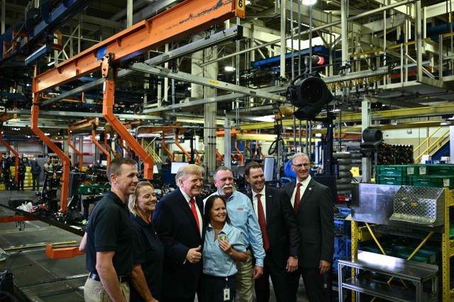 US President Donald Trump poses for a photo with employees as he tours the Peterbilt Motors facility in Denton, Texas, on October 1, 2026. (Photo by Kent NISHIMURA / AFP)