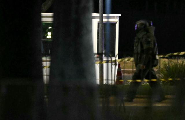 A Brazilian police officer inspects the area of a possible bomb in a backpack outside the Supreme Court headquarters in Brasilia on October 1, 2026. Brazilian police are investigating a possible bomb placed in a backpack thrown outside the Supreme Court, the country's highest tribunal reported on October 1, 2026, three days before presidential elections begin. (Photo by Evaristo SA / AFP)