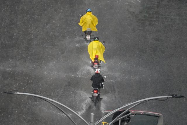Motorcyclists ride through a flooded street during heavy rainfall in Mexico City on October 1, 2026. (Photo by Yuri CORTEZ / AFP)