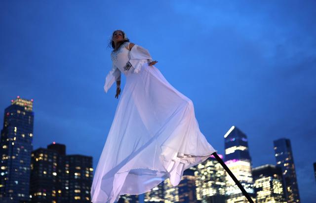A woman performs during 14th annual edition of "Le Diner en Blanc New York" at Pier 84 in Hudson River Park on Manhattan's West Side on October 1, 2026. The legendary all-white secret pop-up, the location of which is reveald hours before the event, draws guests who dress in head-to-toe white attire for an under the stars dining experience. (Photo by TIMOTHY A. CLARY / AFP)