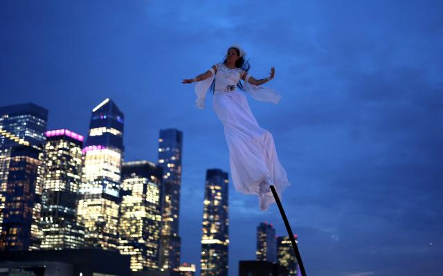 A woman performs during 14th annual edition of "Le Diner en Blanc New York" at Pier 84 in Hudson River Park on Manhattan's West Side on October 1, 2026. The legendary all-white secret pop-up, the location of which is reveald hours before the event, draws guests who dress in head-to-toe white attire for an under the stars dining experience. (Photo by TIMOTHY A. CLARY / AFP)