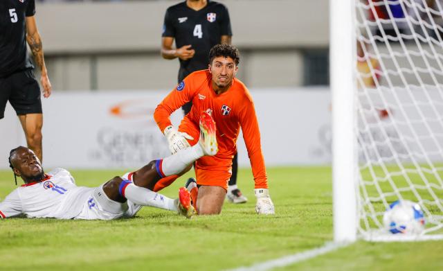 Haiti's forward #11 Louicius Deedson (L) scores his team's first goal past Dominican Republic's goalkeeper #01 Xavier Valdez during the Concacaf Nations League Cup football match between Dominican Republic and Haiti at the Felix Sanchez Olympic Stadium in Santo Domingo on October 1, 2026. (Photo by Nelson PULIDO / AFP)