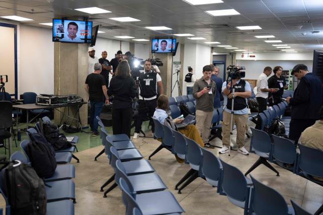 Journalists check their cellphones at TV Globo studios after the cancellation of the presidential debate in Rio de Janeiro, Brazil on October 1, 2026. The debate was cancelled after Brazil's President and Presidential candidate Luiz Inacio Lula da Silva and right-wing Presidential candidate Flavio Bolsonaro refused to attend. (Photo by Pablo PORCIUNCULA / AFP)