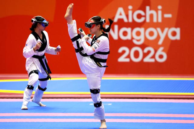 Vietnam’s Ngoc Tuyet Sang Chau (R) competes against Thailand’s Sasikarn Tongchan in the mixed individual virtual taekwondo competition during the 2026 Asian Games at the Toyohashi Gymnasium in Toyohashi on October 2, 2026. (Photo by DAVID GRAY / AFP)