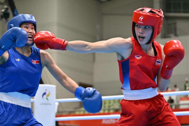 Thailand's Natnicha Chongprongklang (red) competes against North Korea's Pang Chol Mi in the women's 54kg gold medal boxing bout during the 2026 Asian Games at Nishio Gymnasium in Nishio on October 2, 2026. (Photo by MOHD RASFAN / AFP)