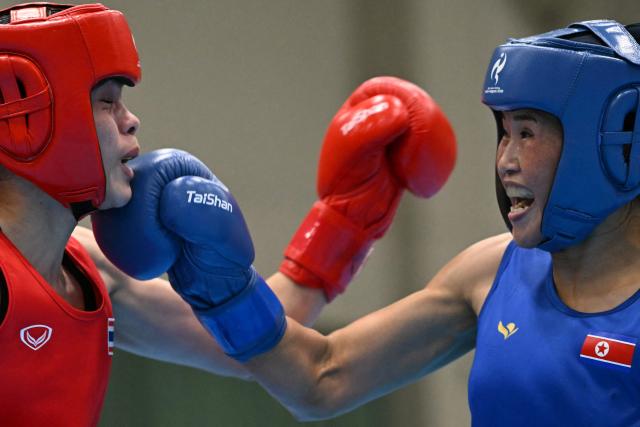 Thailand's Natnicha Chongprongklang (red) competes against North Korea's Pang Chol Mi in the women's 54kg gold medal boxing bout during the 2026 Asian Games at Nishio Gymnasium in Nishio on October 2, 2026. (Photo by MOHD RASFAN / AFP)