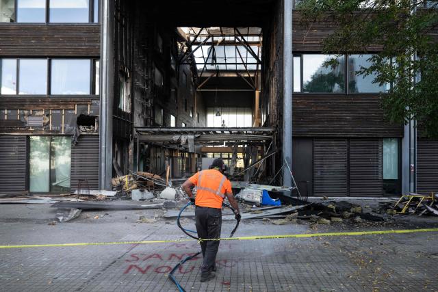 An employee cleans a graffiti at the entrance of the Mandela's high school after a fire as protesting students carry out blockading action in Nantes, western France, on October 2, 2026. Since late September, students have staged protests outside schools over grievances ranging from timetables, class sizes and a shortage of teachers to overheated classrooms during this year's heatwaves. The protests started in the Ile-de-France region around Paris but have now spread to other cities nationwide. (Photo by Sebastien Salom-Gomis / AFP)