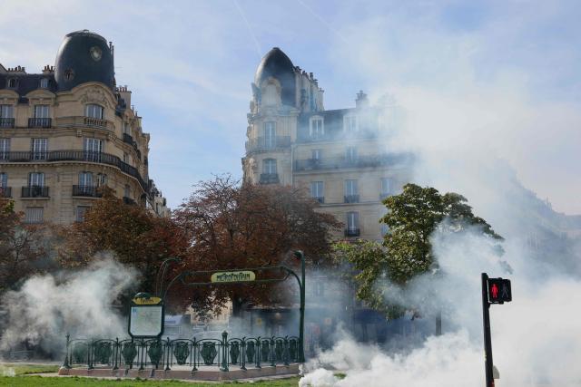 This photograph shows tear gas as protesting students carry out blockading action at place de la Nation, in Paris, on October 2, 2026. Since late September, students have staged protests outside schools over grievances ranging from timetables, class sizes and a shortage of teachers to overheated classrooms during this year's heatwaves. The protests started in the Ile-de-France region around Paris but have now spread to other cities nationwide. (Photo by Thomas SAMSON / AFP)