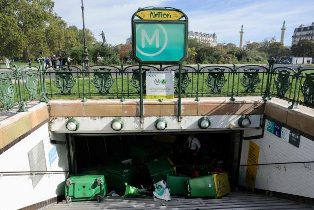 This photograph shows bins blocking the access to an entry of Nation's subway station as protesting students carry out blockading action near place de la Nation, in Paris, on October 2, 2026. Since late September, students have staged protests outside schools over grievances ranging from timetables, class sizes and a shortage of teachers to overheated classrooms during this year's heatwaves. The protests started in the Ile-de-France region around Paris but have now spread to other cities nationwide. (Photo by Thomas SAMSON / AFP)