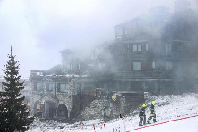 (FILES) Firefighters walk by the five-star Grandes Alpes hotel in the upscale French Alpine ski resort of Courchevel where a fire broke out the evening before, forcing the evacuation of 83 occupants, on January 28, 2026. The appeal trial over the fatal Courchevel fire is scheduled to continue until Octobre 7, 2026. (Photo by Alex MARTIN / AFP)