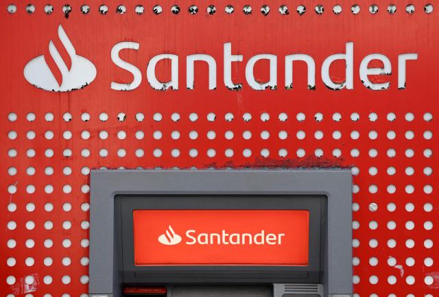 (FILES) A logo is pictured above an ATM cash machine at a branch of a Santander bank in Liverpool, north west England, on March 19, 2025. The trial of 27 people for tax fraud and money laundering through the Spanish bank Santander is scheduled to continue until October 14, 2026 in Paris. (Photo by Paul ELLIS / AFP)