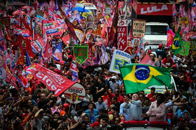 Brazil's President and presidential candidate Luiz Inacio Lula da Silva (L) waves a nationall flag next to candidates for the Federal Senate Benedita da Silva (PT)  during a campaign walk through downtown Rio de Janeiro, Brazil, on October 2, 2026. Next October 4 Lula da Silva 80, faces off against the 45-year-old right-wing senator Flavio Bolsonaro, who is trying to ride the regional conservative wave encouraged by US President Donald Trump. (Photo by Pablo PORCIUNCULA / AFP)