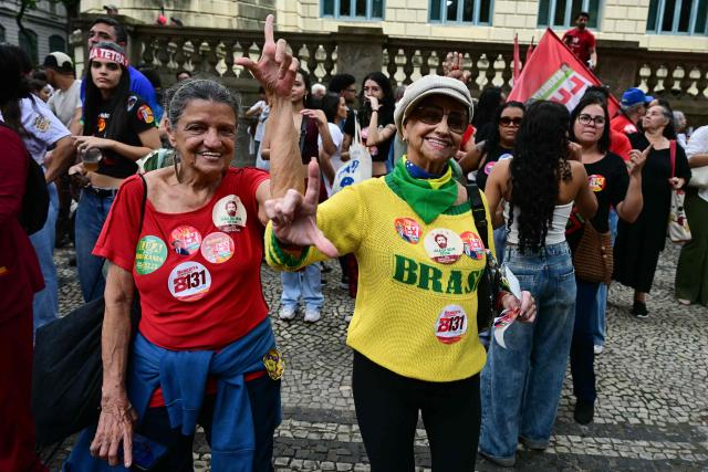 Supporters of Brazil's President and presidential candidate Luiz Inacio Lula da Silva take part in a campaign walk through downtown Rio de Janeiro, Brazil on October 2, 2026. Next October 4 Lula da Silva 80, faces off against the 45-year-old right-wing senator Flavio Bolsonaro, who is trying to ride the regional conservative wave encouraged by US President Donald Trump. (Photo by Pablo PORCIUNCULA / AFP)