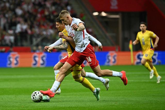 Poland's midfielder #16 Wiktor Nowak (R) and Romania's midfielder #20 Dennis Man (L) vie for the ball during the UEFA Nations League Group B4 football match between Poland and Romania at the National Stadium in Warsaw on October 2, 2026. (Photo by Sergei GAPON / AFP)