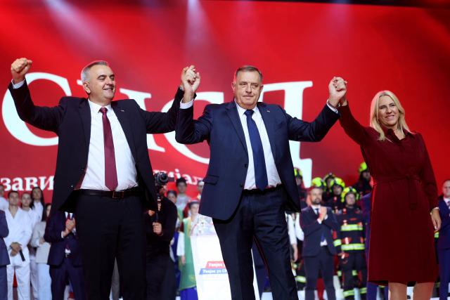 Alliance of Independent Social Democrats (SNSD) leader Milorad Dodik (C), SNSD candidate for the Serb seat in Bosnia's tripartite presidency Zeljka Cvijanovic (R) and the party's candidate for president of Republika Srpska Savo Minic stand on stage during the party's final pre-election rally in Banja Luka, Bosnia and Herzegovina, on October 2, 2026, ahead of the country's general elections on October 4. Bosnia votes in general elections on October 4, 2026 after years of political turmoil and stalled reforms, with rival parties campaigning on ethnic divisions rooted in its 1990s war. Voters will elect a dizzying number of officials across multiple tiers of government, in a complex system that has held the partitioned country together since the 1995 peace deal. Its key race will be for the tripartite presidency, split between Bosnian Muslims or Bosniaks, and the Serb and Croat ethnic groups, with frontrunners pitting visions of a united country against greater autonomy for its entities. (Photo by AFP)