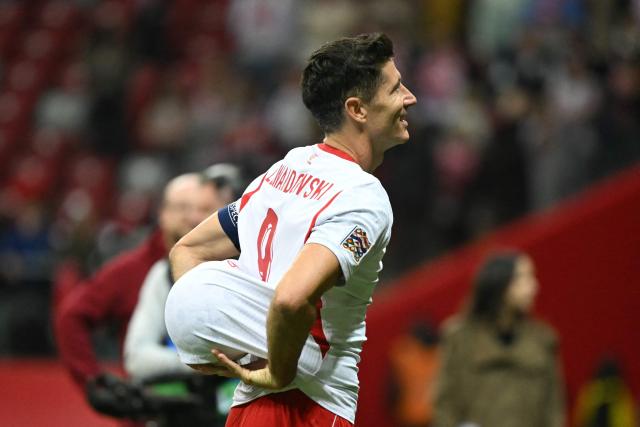 Poland's forward #09 Robert Lewandowski with the match ball for his hattrick as he celebrates after the UEFA Nations League Group B4 football match between Poland and Romania at the National Stadium in Warsaw on October 2, 2026. (Photo by Sergei GAPON / AFP)