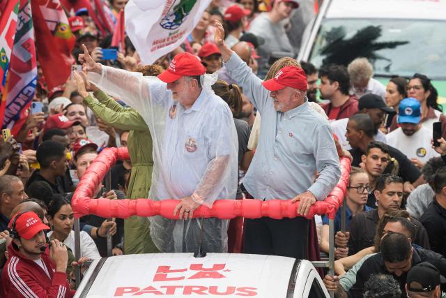Brazil's President and presidential candidate Luiz Inacio Lula da Silva (R) and federal deputy Patrus Ananias (L) wave supporters during a campaign rally in Belo Horizonte, Minas Gerais state, Brazil on October 2, 2026. Brazilians go to the polls on October 4, 2026, in a tight race led by leftist President Luiz Inacio Lula da Silva and right-wing senator Flavio Bolsonaro, son of former president Jair Bolsonaro. (Photo by Gledston Tavares / AFP)