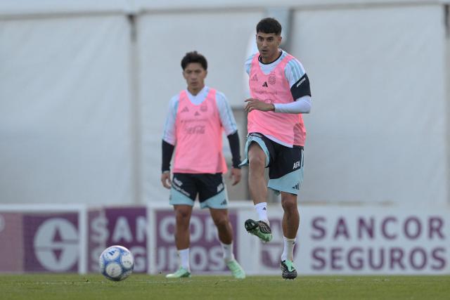 Argentina's midfielder Exequiel Palacios (R) passes the ball next to defender Lisandro Martinez during a football training session at the Argentine Football Association (AFA) training camp in Ezeiza, Buenos Aires Province, on October 2, 2026, ahead of the friendly matches against Burkina Faso and Benin. (Photo by JUAN MABROMATA / AFP)
