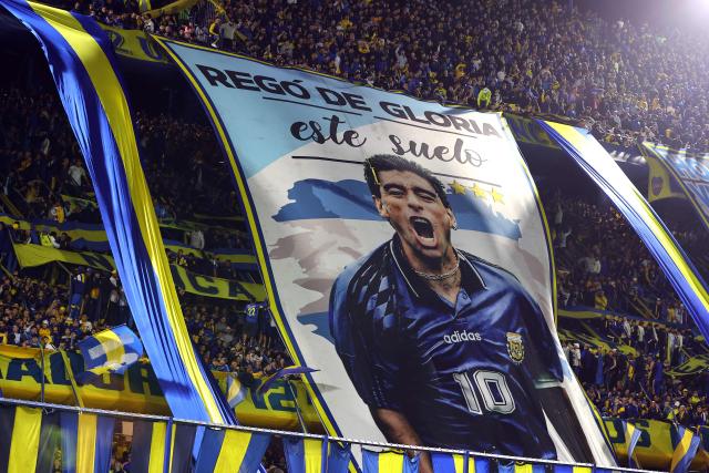 Boca Juniors' fans display a giant flag depicting Argentine football legend Diego Maradona during the Argentine Professional League 2026 Clausura tournament football match between Boca Juniors and Union de Santa Fe at La Bombonera stadium in Buenos Aires on October 2, 2026. (Photo by Alejandro PAGNI / AFP)