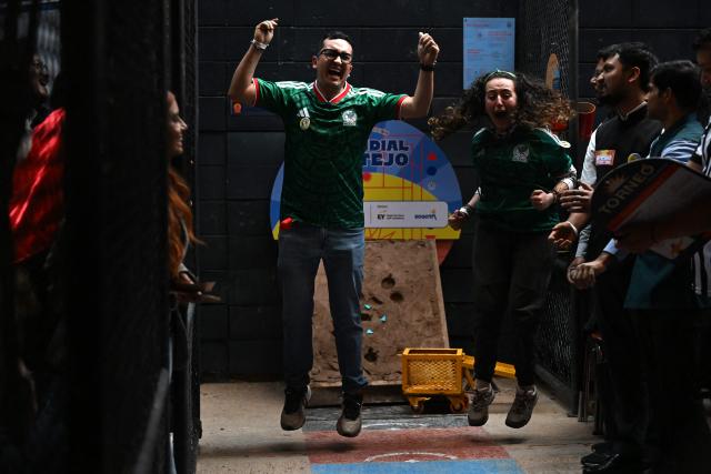 Members of the Mexican delegation celebrate during the fourth edition of the Tejo World Championship, a traditional Colombian sport, in Bogota on October 2, 2026. Tejo is Colombia's national sport, in which players throw a heavy metal disc at a clay-filled target, aiming to hit small gunpowder-filled packets that explode on impact. (Photo by Raul ARBOLEDA / AFP)